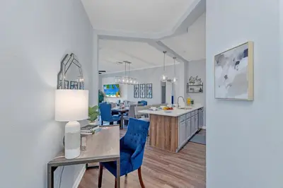 a kitchen and dining room with a table and blue chairs at Top floor condo with view of lake, pool and fireworks! Next to Convention Center! in Orlando