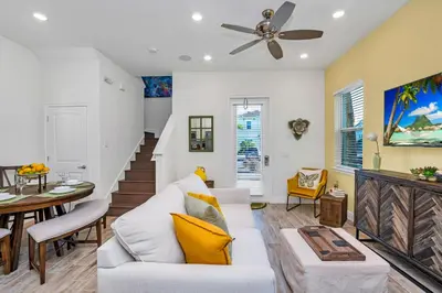 a living room with a white couch and a ceiling fan at Margaritaville Cottage, PRIVATE POOL, Near Disney in Orlando