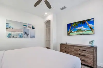 a white bedroom with a bed and a dresser at Margaritaville Cottage, PRIVATE POOL, Near Disney in Orlando