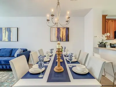 a dining room with a table with chairs and a blue and white dining room at Stylish Vista Cay Townhome Near Conv. Ctr I-Dr. in Orlando