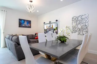 a dining room and living room with a table and chairs at Themed Disney House 5 min to Disney Parks, Heated Pool, Jacuzzi, Gym and more in Orlando
