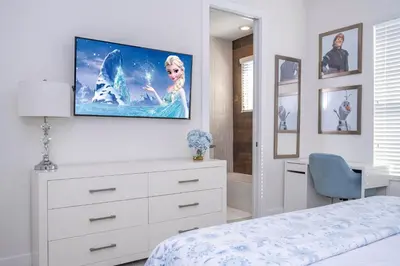 a bedroom with a tv hanging on the wall at Themed Disney House 5 min to Disney Parks, Heated Pool, Jacuzzi, Gym and more in Orlando