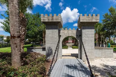 a bridge in a park with a palm tree at Windsor Hills Resort 3 Bedroom Condo 5 Minutes to Disney in Orlando