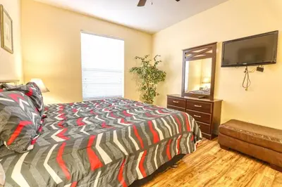 a bedroom with a bed and a flat screen tv at Windsor Palms Resort 3 Bedroom Condo 6 Miles to Disney in Kissimmee