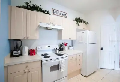 a white kitchen with a stove and a refrigerator at Windsor Palms Resort 3 Bedroom Condo 6 Miles to Disney in Kissimmee