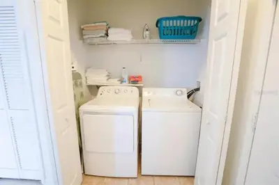 a small laundry room with a washer and dryer at Windsor Palms Resort 3 Bedroom Condo 6 Miles to Disney in Kissimmee