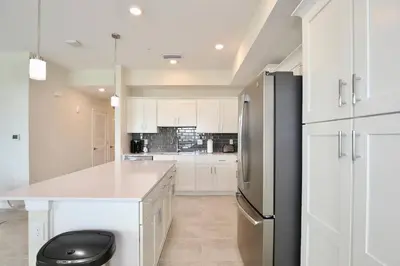 a kitchen with white cabinets and a black refrigerator at Great apartment in Storey Lake resort with great amenities next to Disney! in Kissimmee