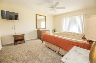 a bedroom with a bed and a flat screen tv at Royal Palm Bay 3 Bedroom Condo Resort Pool 10 Min Disney in Kissimmee