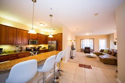 a kitchen and living room with a counter and chairs at Vista Cay Resort 3 Bedroom Condo 2 Miles to Universal Orlando in Orlando