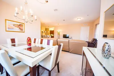 a dining room and living room with a white table and chairs at Vista Cay Resort 3 Bedroom Condo 2 Miles to Universal Orlando in Orlando