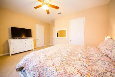 a bedroom with a bed and a flat screen tv at Vista Cay Resort 3 Bedroom Condo 2 Miles to Universal Orlando in Orlando