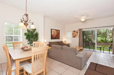 a dining room and living room with a couch and a table at 3Br 3Bath Private Townhome 10min Disney 1270ft in Kissimmee