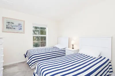 two beds in a white room with a window at 3Br 3Bath Private Townhome 10min Disney 1270ft in Kissimmee