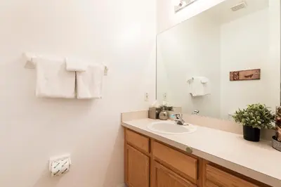 a bathroom with a sink and a mirror at Family Getaway Townhome at Lake Berkley 15min to Disney in Kissimmee