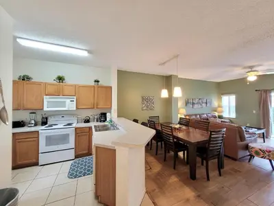 a kitchen and living room with a table and a dining room at Family Getaway Townhome at Lake Berkley 15min to Disney in Kissimmee