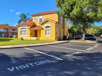 a yellow house with a sign that says visitors at Family Getaway Townhome at Lake Berkley 15min to Disney in Kissimmee