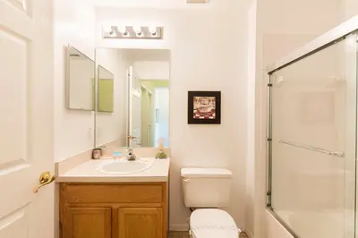 a bathroom with a toilet and a sink and a shower at Family Getaway Townhome at Lake Berkley 15min to Disney in Kissimmee