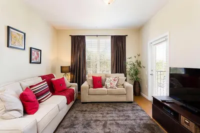 a living room with a white couch and red pillows at 3Br 2Bath Condo Balcony 5min Conv Center 1410ft in Orlando