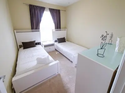 a bedroom with two beds and a table and a window at 3Br 2Bath Condo Balcony 5min Conv Center 1410ft in Orlando