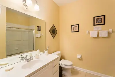 a bathroom with a sink and a toilet and a mirror at 3Br 2Bath Condo Balcony 5min Conv Center 2087ft in Orlando