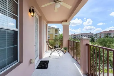 a balcony with a chair and a ceiling fan at 3Br 2Bath Condo Balcony 5min Conv Center 2087ft in Orlando