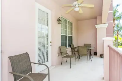 a patio with chairs and a table and a ceiling fan at Spacious Vista Cay Condo near Universal Studios in Orlando