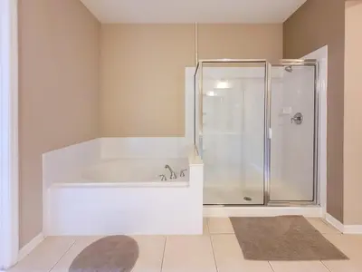 a bathroom with a white tub and a shower at Spacious Vista Cay Condo near Universal Studios in Orlando