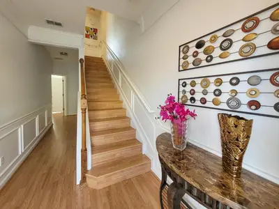 a hallway with stairs and a vase of flowers on a table at 3Br 4 Bath Large Condo 5min Conv Center 1732ft in Orlando