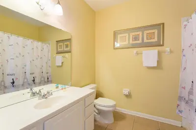 a bathroom with a white sink and a toilet at Renovated 4Br Condo 5min Conv Center in Orlando
