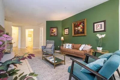 a living room with green walls and a couch and chairs at Renovated 4Br Condo 5min Conv Center in Orlando