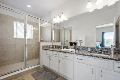 a bathroom with two sinks and a shower at 5Br 5Bath Pvt Home BBQ Pool 15min Disney 3056ft in Kissimmee