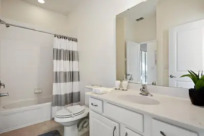 a white bathroom with a sink and a toilet at 5Br 5Bath Pvt Home BBQ Pool 15min Disney 3056ft in Kissimmee