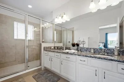 a bathroom with two sinks and a shower at 5Br 5Bath Pvt Home BBQ Pool 15min Disney 3056ft in Kissimmee
