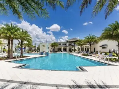 a large swimming pool with palm trees and a building at 5Br 5Bath Pvt Home BBQ Pool 15min Disney 3056ft in Kissimmee