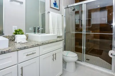 a bathroom with a toilet and a sink and a shower at 3 BR 3BA 1678ft 5min Disneyworld Resort style in Orlando