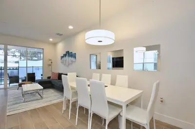 a dining room with a white table and white chairs at Great 4 bedroom townhouse in lux resort Hidden Forest, with private pool! in Orlando