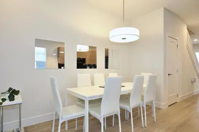 a dining room with a white table and white chairs at Great 4 bedroom townhouse in lux resort Hidden Forest, with private pool! in Orlando