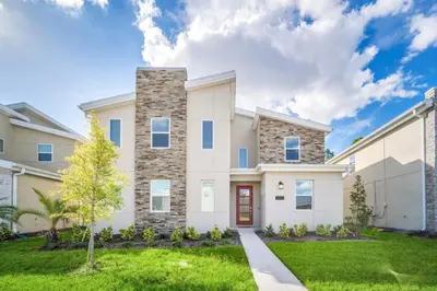 a large white house with a grass yard at 9 Bed Storey Lake Villa Pictures Coming Soon home in Kissimmee