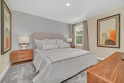 a white bedroom with a large bed and a window at 9 Bed Storey Lake Villa Pictures Coming Soon home in Kissimmee