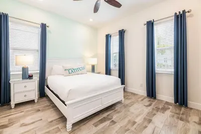 a bedroom with a white bed and blue windows at Lovely Cottage Near Disney With Margaritaville Resort & Island H20 Access - 8145Su in Orlando