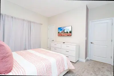 a white bedroom with a bed and a dresser at Gorgeous 4 Bd w/ Pool at Champions Gate Resort 1020 in Orlando