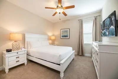 a bedroom with a white bed and a ceiling fan at Modern Home With Pool Table Near Disney With Waterpark & Resort Access At Encore Resort - 7644Ff in Kissimmee
