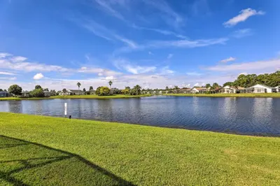a view of a lake with grass and houses at 8 Mi to Disney World Home with Lanai and Game Room! in Kissimmee