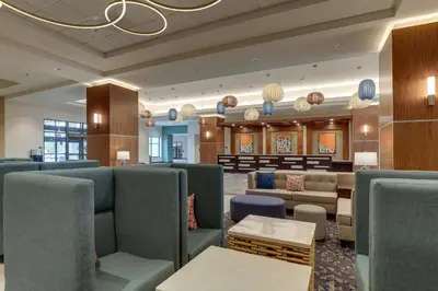 a waiting room with green chairs and a waiting roomasteryasteryasteryasteryasteryastery at Drury Plaza Hotel Orlando - Disney Springs Area in Orlando
