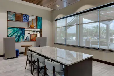 a dining room with a table and some chairs at Drury Plaza Hotel Orlando - Disney Springs Area in Orlando