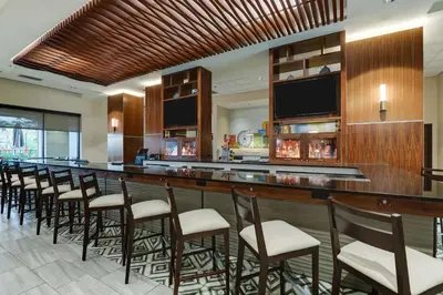 a bar with a row of chairs in a room at Drury Plaza Hotel Orlando - Disney Springs Area in Orlando