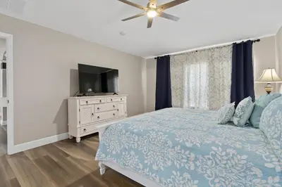 a bedroom with a blue bed and a television at WindsorHills Villa Pool Resort Amenities Minutes to Disney in Orlando