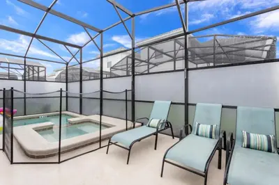 a room with a swimming pool and two chairs at Magical Memories Await at Jimmy Cricket's Retreat in Kissimmee