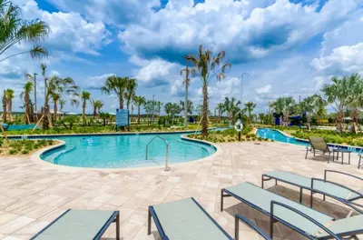 a pool at the resort with chairs and palm trees at Magical Memories Await at Jimmy Cricket's Retreat in Kissimmee