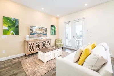 a living room with a white couch and a tv at Fabulous Cottage With Private Pool Near Disney With Margaritaville Resort & Island H2O Access - 8094Kd in Orlando